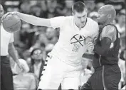  ?? David Zalubowski Associated Press ?? THE CLIPPERS’ Marreese Speights, right, tries to slow down a drive by the Nuggets’ Nikola Jokic.