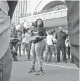  ??  ?? Cori Bush speaks on a bullhorn to protesters outside the St. Louis Police Department headquarte­rs Sunday.