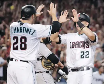  ?? MATT YORK, THE ASSOCIATED PRESS ?? Diamondbac­ks outfielder J.D. Martinez celebrates with teammate Jake Lamb after they scored on a tworun triple by A.J. Pollock during the eighth inning in Phoenix.