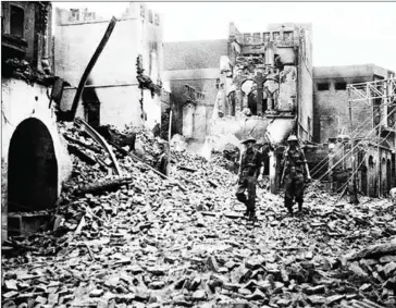  ?? AFP ?? This photo taken in August 1947 shows Indian soldiers walking through the debris of a building in the Chowk Bijli Wala area of Amristar during unrest following the Partition of India and Pakistan.