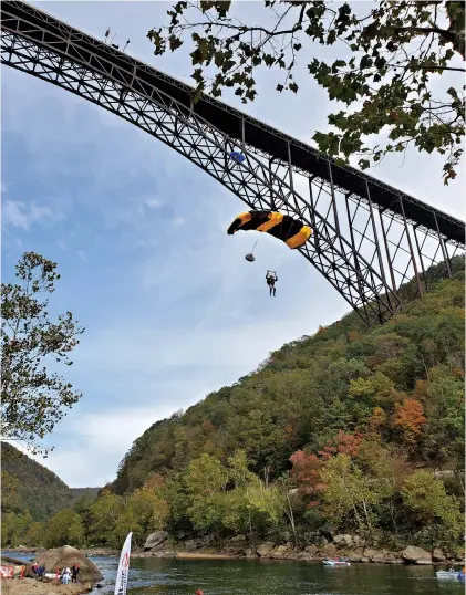  ?? Bridge Day ?? ■ An annual event features jumpers parachutin­g 876 feet from the New River Gorge Bridge, the longest steel arch span in the Western Hemisphere, to the water at the bottom of the scenic canyon in West Virginia.