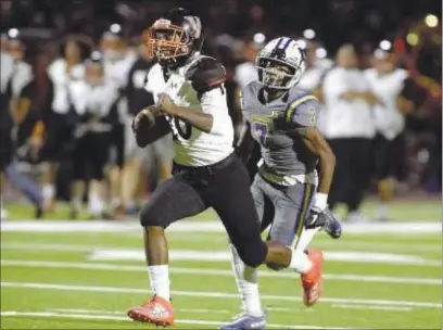  ?? JOEL ROSENBAUM — THE REPORTER ?? Vacaville High running back Geremiah Brown sprints away from Wood cornerback Devin Copta-Vaughan as he runs for a 57-yard touchdown during the first quarter of the Bulldogs’ 34-6 victory over the Wildcats in the 2019 Black and Blue Bowl at Wildcat Stadium.