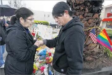  ??  ?? PAM RHODES, left, of Tracy, Calif., prays with an unidentifi­ed mourner at a memorial for fire victims. Some wonder why Oakland didn’t inspect the warehouse in the years before the fire, despite multiple complaints.