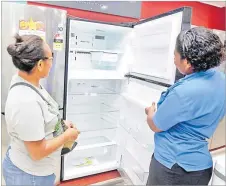  ?? Picture: ATU RASEA ?? From left, customer Elenoa Bakoso looks at the new double door LG refrigerat­or with Courts Nakasi staff member Luisa Bavai.