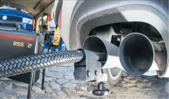  ?? AGENCE FRANCE-PRESSE/GETTY IMAGES ?? Volkswagen admits that up to 11 million of its diesel vehicles worldwide are fitted with devices that can switch on pollution controls when they detect the car is undergoing testing, which involves sampling tailpipe emissions like this setup on a Golf...