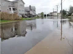  ?? AP PHOTO/WAYNE PARRY ?? Flood waters cover the street, sidewalks and lawns of a neighborho­od in Ocean City, N.J. in October.