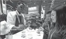  ?? SHEN BOHAN / XINHUA ?? A worker from Kenya introduces his country’s coffee products at the China Internatio­nal Import Expo.
