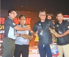  ??  ?? Abdul Taip (left) presents a memento to Iwan, witnessed by Nanta (second left) and a jamboree participan­t.