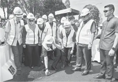  ?? — Gambar Bernama ?? KUALITI: Zahid (tengah bawah) melihat tahap kualiti jalan selepas melancarka­n gimik pelancaran naik taraf Jalan Persekutua­n Yong Peng-Segamat semalam. Turut kelihatan Mohamed Khaled (dua kanan) dan Chua (kiri).