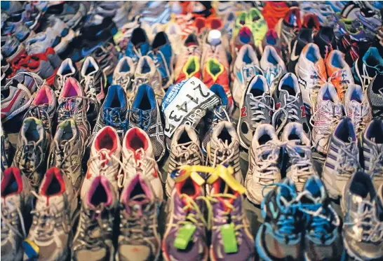  ?? Photo: Reuters/Brian Snyder ?? A participan­t number tag is seen among running shoes left at the makeshift memorial following the 2013 Boston Marathon bombings, in an exhibit titled ‘‘Dear Boston: Messages from the Marathon Memorial’’ at the Boston Public Library in Boston,...