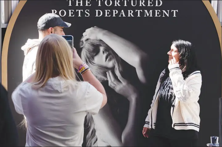  ?? RICHARD VOGEL / ASSOCIATED PRESS ?? Taylor Swift fans take selfies Wednesday at a new pop-up opening to celebrate Swift’s new album, “The Tortured Poets Department,” at the Grove in Los Angeles.