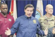  ?? Stephen M. Dowell / Orlando Sentinel via Associated Press ?? Aflorida Gov. Ron Desantis, center, speaks about Hurricane Dorian during a news conference at the Orange County Emergency Operations Center Friday in Orlando. State Sen. Randolph Bracy, left, and Florida Adj. Gen. General James Eifert, right, listen.