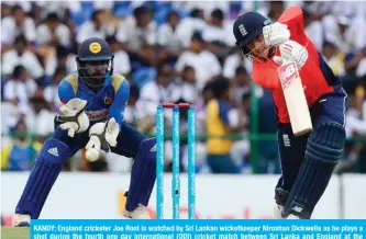  ?? — AFP ?? KANDY: England cricketer Joe Root is watched by Sri Lankan wicketkeep­er Niroshan Dickwella as he plays a shot during the fourth one day internatio­nal (ODI) cricket match between Sri Lanka and England at the Pallekele Internatio­nal Cricket Stadium in Kandy yesterday.