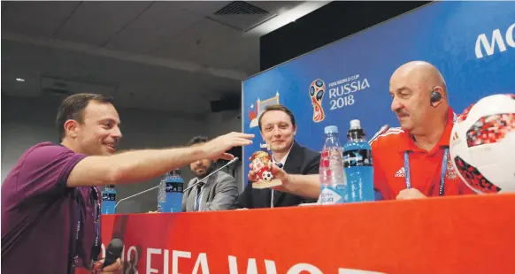  ?? Reuters ?? A member of the media presents a gift to Russia manager Stanislav Cherchesov at the news conference ahead of their second-round match against Spain