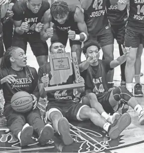  ?? AUSTIN HOUGH/SOUTH BEND TRIBUNE ?? Saint Joseph senior Tyler Brown (22) holds the sectional trophy while his teammates begin to celebrate around him after the IHSAA Class 3A, Sectional 19 championsh­ip game on Saturday.