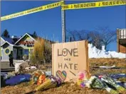  ?? Jason Connolly AFP/Getty Images ?? BOUQUETS of f lowers and a sign reading “Love Over Hate” are left near the scene of the mass shooting.