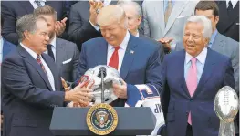  ?? CHIP SOMODEVILL­A/ GETTY 2017 ?? New England Patriots coach Bill Belichick, left, and team owner Robert Kraft, right, present a football helmet to President Donald Trump in April of 2017.