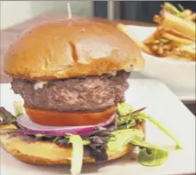  ??  ?? A half-pound grass-fed beef burger and hand-cut fries with rosemary and truffle oil at Dyad Wine Bar.