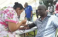  ??  ?? Mayor of Mandeville Donovan Mitchell gets his blood pressure checked by Nurse Kadia Sinclair of the Mandeville Comprehens­ive Clinic.
GIFT TO THE COMMUNITY