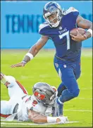  ?? Mark Zaleski The Associated Press ?? Buccaneers linebacker Joe Tryon-shoyinka trips Titans quarterbac­k Malik Willis in Tennessee’s victory Saturday.