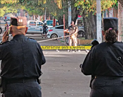  ??  ?? ATAQUE. POLICÍAS COLOCAN CINTA AMARILLA EN EL LUGAR DONDE FUERON ASESINADOS LOS SOLDADOS, A TRES CUADRAS DE LLEGAR A LA GUARNICIÓN MILITAR.