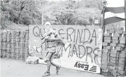  ??  ?? SEKAT: Seorang pembantah menyekat lebuh raya Pan-Amerika semasa demonstras­i terhadap kerajaan Ortega di Masaya, Nicaragua kelmarin. — Gambar Reuters