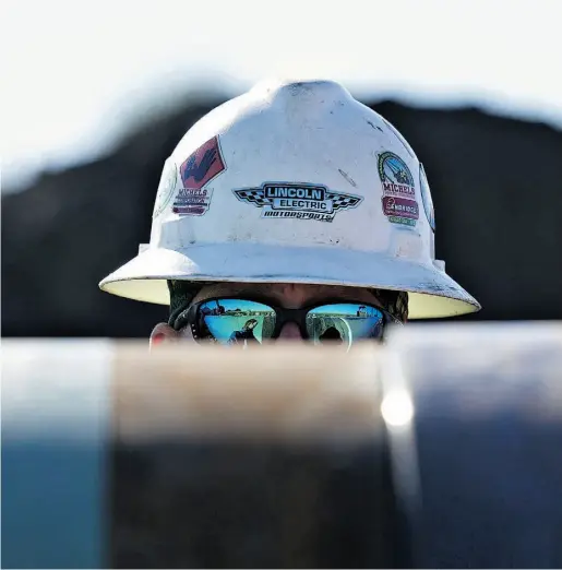  ?? Daniel Acker / Bloomberg files ?? A Michels Corp. contractor at the Flanagan South crude oil pipeline outside Goodfield, Ill. The pipeline is being constructe­d by a subsidiary of Enbridge Inc., whose investment rating was downgraded to BBB+ in Q3 by Standard & Poor’s.