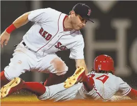  ?? StaFF PHOtO By CHRIstOPHe­R eVans ?? GOING NOWHERE: Ian Kinsler tags out the Phillies’ Roman Quinn, who was attempting to steal second base during the sixth inning of the Red Sox’ 3-1 loss last night at Fenway Park.