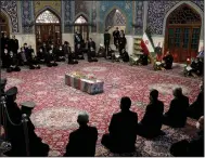  ?? (AP/Iranian Defense Ministry) ?? People pray at a Saturday funeral in the city of Mashhad over the flag-draped coffin of Mohsen Fakhrizade­h, an Iranian scientist linked to the country’s disbanded military nuclear program, who was killed Friday.