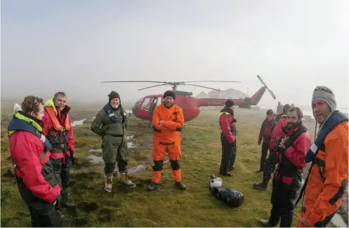  ??  ?? ABOVE / A cold misty day on South Georgia Island, 2013: Tony is in the centre of the group and third from left is fellow pilot Peter Garden.