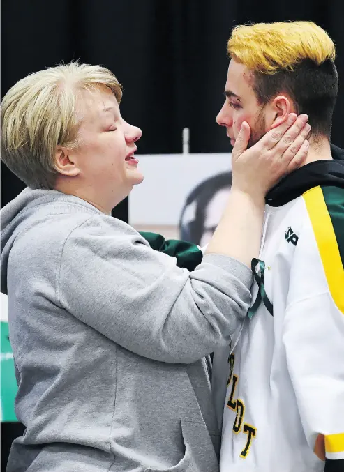  ?? PHOTOS: JONATHAN HAYWARD / THE CANADIAN PRESS ?? Humboldt Broncos player Nick Shumlanski is comforted by a mourner during a vigil at the team’s home, Elgar Petersen Arena in Humboldt, Sask., on Sunday. Thousands turned out to offer prayers and support.