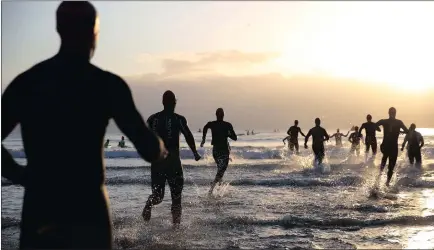  ?? PICTURE: MOTSHWARI MOFOKENG ?? By dawn’s early light, competitor­s run into the surf for the first leg of the Standard Bank Ironman 70.3 Durban competitio­n at uShaka beach yesterday, to tackle the 1.9km swimming leg of the three-part course of events. P10