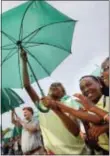  ?? AP ?? Randle Highlands Elementary School fourth graders, center, from left, Zaria Russell, Zani La McElwain, and Kelsi Williams raise their umbrella while assembling into a living version of the National Park Service’s iconic Arrowhead emblem, near the...