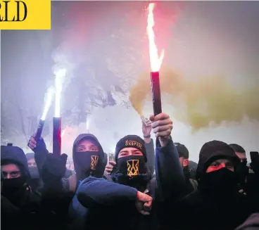  ?? EFREM LUKATSKY / AP PHOTO ?? Volunteers with the right-wing paramilita­ry Azov National Corps light flares during a rally at the Ukrainian parliament in Kyiv on Monday, where they brandished yellow-and-blue flags and a banner reading, “Don’t back down!”