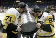  ?? MARK HUMPHREY — THE ASSOCIATED PRESS ?? The Penguins’ Evgeni Malkin, left, and Sidney Crosby kiss the Stanley Cup after defeating the Predators in Game 6 of the Stanley Cup Final on Sunday.