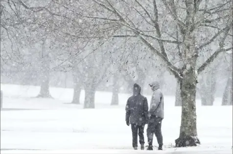  ?? George Walker IV/The Tennessean via AP ?? A couple walks through McCabe Golf Course during a winter storm in Nashville, Tenn., on Sunday morning. The storm brought rain, snow and sleet to Middle Tennessee.