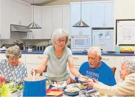  ?? | HEIDI DE MARCO, KAISER HEALTH NEWS, VIA USA TODAY ?? Carolyn Langenkamp, 68, helps serve the family- style dinner at her California co- housing dwelling.