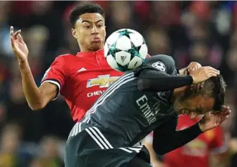  ?? OLI SCARFF/AFP/GETTY IMAGES ?? Manchester United midfielder Jesse Lingard, left, vies with Benfica midfielder Andreas Samaris during a Champions League Group A match at Old Trafford on Tuesday. Manchester United prevailed 2-0.