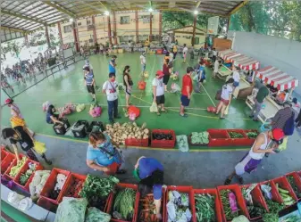  ?? PHOTO BY XINHUA ?? Customers wait in line to buy vegetables at a makeshift market in the Philippine capital Manila on Friday as a measure to stem the growing spread of the coronaviru­s.