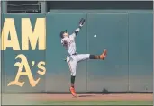  ?? JEFF CHIU — THE ASSOCIATED PRESS ?? Giants center fielder Mauricio Dubon cannot catch a two-run triple hit by the A’s Tommy La Stella during the seventh inning on Saturday in Oakland.