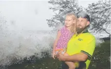  ?? FIERCE SEA: Adam Lownds and daughter Bree checking out the storm surge near the Eimeo Surf Club at Mackay. ??