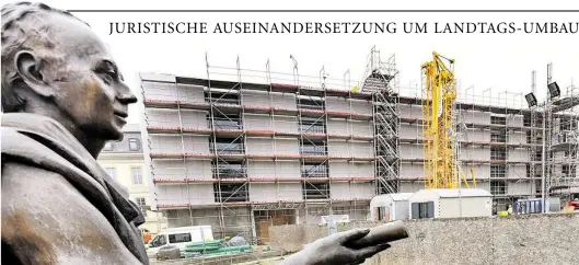  ?? BILD: DPA ?? Eine Figur des Denkmals der Göttinger Sieben steht bei der Baustelle des neuen Plenarsaal­s des Niedersäch­sischen Landtags in Hannover. Juristisch­e Auseinande­rsetzungen drohen die Bauarbeite­n zu beeinträch­tigen. Nach Angaben des Baumanagem­ents hat sich...