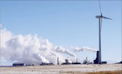  ?? NEWS PHOTO COLLIN GALLANT ?? The CF Industries fertilizer plant in Medicine Hat is shown with a wind turbine, located on the neighbouri­ng Box Springs Wind Farm, in the foreground. The global ammonia producer is exploring low-carbon processes and potential expansions, according to a business plan announced last fall.