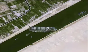  ?? CNES/AFP via Getty Images ?? The Taiwan-owned Ever Given container ship, a 1,300-foot-long vessel, reamins lodged sideways Thursday, impeding all traffic across the waterway of Egypt's Suez Canal.
