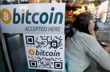  ?? THE CANADIAN PRESS/JONATHA N HAYWARD ?? The success of bitcoin has spurred the launch of hundreds of copycat digital payment systems looking to cash in on the popularity of the cryptocurr­ency. A Bitcoin ATM sticker is posted to the window of a coffee shop in downtown Vancouver .
