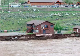  ?? SAM GLOTZBACH VIA AP ?? The flooding Yellowston­e River undercuts the river bank Monday, threatenin­g a house and a garage in Gardiner, Montana.