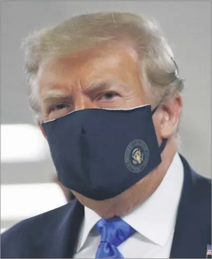  ?? ASSOCIATED PRESS ?? President Donald Trump wears a face mask as he walks down a hallway during a visit to Walter Reed National Military Medical Center in Bethesda, Md., on July 11.