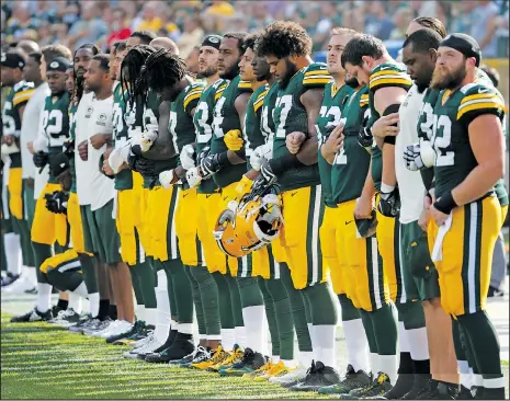  ??  ?? Green Bay Packers players lock arms during the American national anthem prior to yesterday afternoon’s National Football League game against the visiting Cincinnati Bengals.