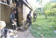  ?? AFP / Getty Images ?? Police and soldiers search for Abu Sayyaf rebels in a village in Inabanga, in the central Philippine­s.