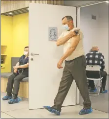  ?? (AP/Roman Yarovitcyn) ?? A man wearing a face mask to protect against coronaviru­s leaves a room after receiving Russia’s Sputnik V coronaviru­s vaccine at a shopping center in Nizhny Novgorod, Russia.